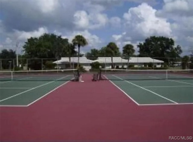 view of tennis court featuring community basketball court and fence