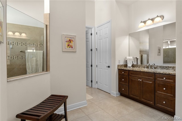 bathroom with a tile shower, tile patterned floors, and vanity