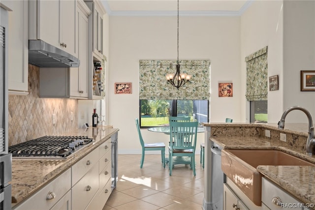 kitchen with stainless steel appliances, a notable chandelier, white cabinetry, hanging light fixtures, and light tile patterned flooring