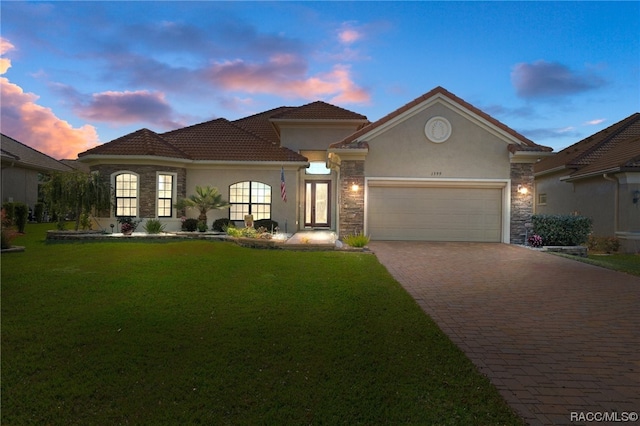 mediterranean / spanish house with a yard and a garage