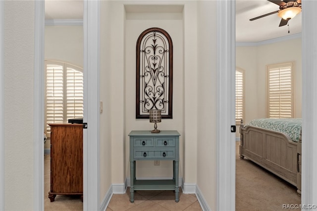 hallway with crown molding and light colored carpet