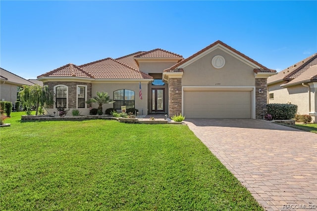 mediterranean / spanish-style home featuring a garage and a front lawn