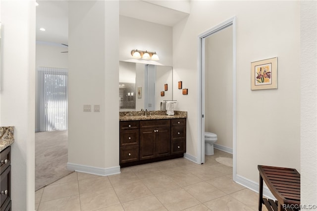 bathroom featuring tile patterned flooring, vanity, and toilet