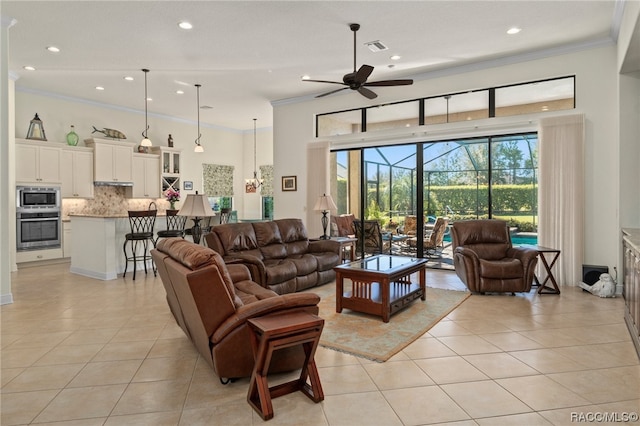 living room featuring ceiling fan with notable chandelier, light tile patterned flooring, and crown molding