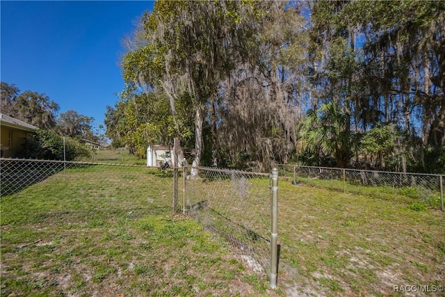 view of yard featuring fence, an outbuilding, and a storage shed