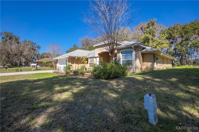 view of front facade featuring a garage, stucco siding, driveway, and a front lawn