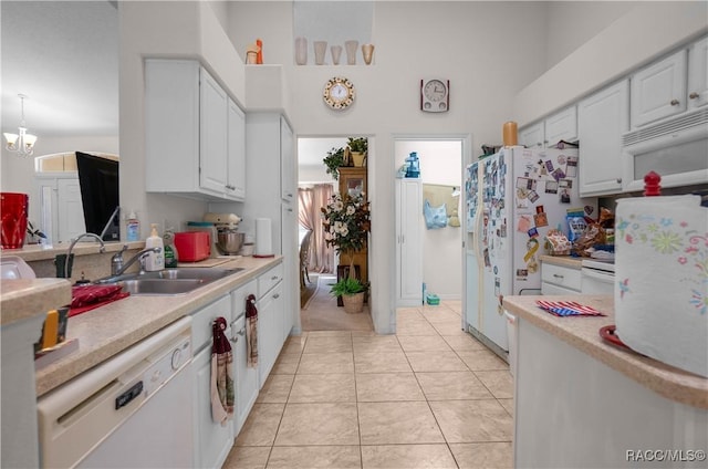 kitchen with light countertops, white appliances, white cabinetry, and a sink
