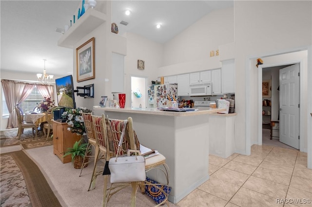 kitchen featuring white cabinets, an inviting chandelier, white appliances, light countertops, and a peninsula