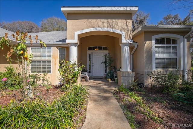 doorway to property featuring stucco siding