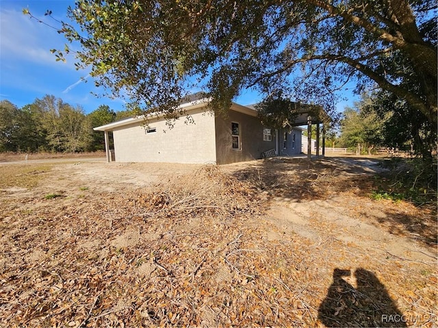 rear view of house featuring a shingled roof and stucco siding