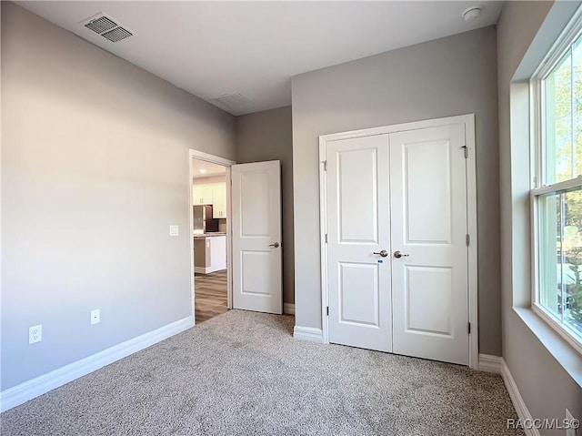 unfurnished bedroom with carpet flooring and a closet