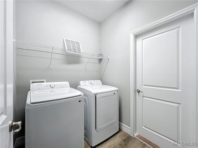 laundry area featuring hardwood / wood-style flooring and washing machine and dryer