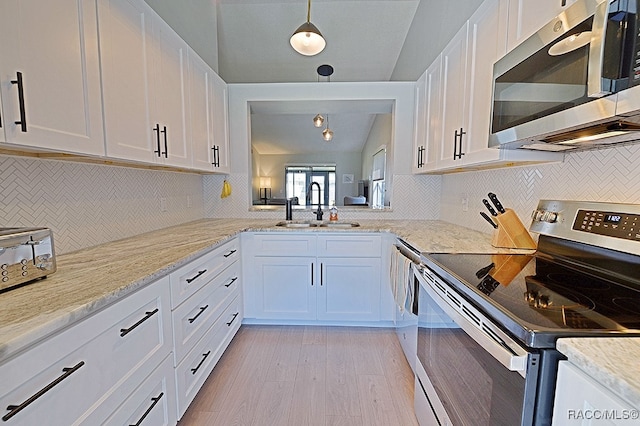 kitchen with white cabinetry, sink, lofted ceiling, appliances with stainless steel finishes, and light wood-type flooring