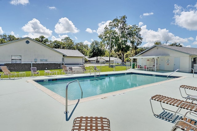 view of pool featuring a lawn and a patio