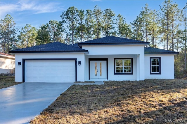 view of front of property with stucco siding, driveway, and an attached garage