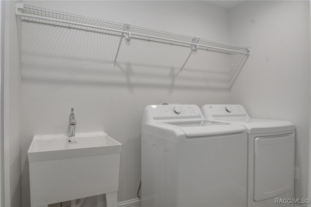 clothes washing area with sink and washing machine and clothes dryer