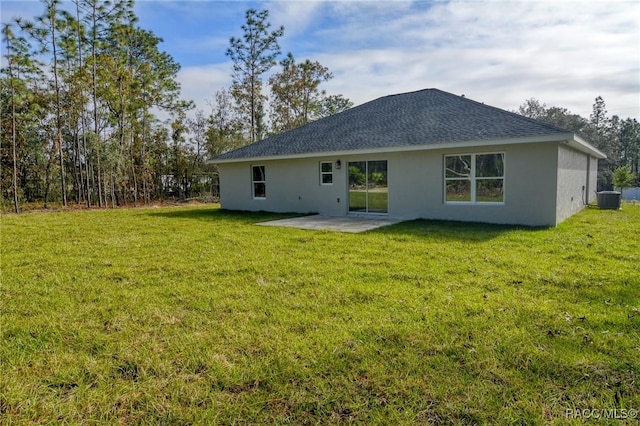 rear view of property with a yard, a patio area, and central air condition unit