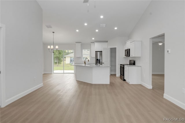 kitchen featuring white cabinets, a center island with sink, hanging light fixtures, light hardwood / wood-style flooring, and appliances with stainless steel finishes