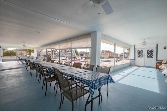 dining space featuring ceiling fan and concrete floors