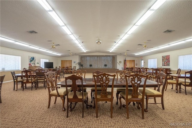 dining area with a textured ceiling, ceiling fan, and carpet