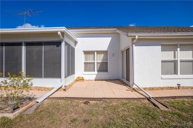 rear view of property with a sunroom and a patio