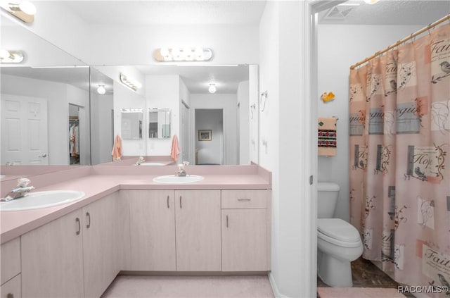 bathroom featuring vanity, a textured ceiling, and toilet