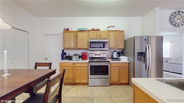 kitchen featuring stainless steel appliances, sink, and light tile patterned floors