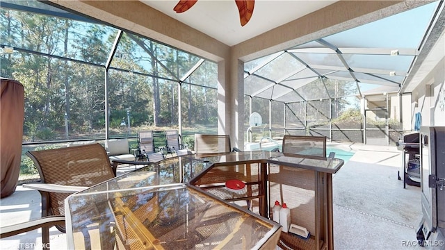 view of patio / terrace with ceiling fan and a lanai