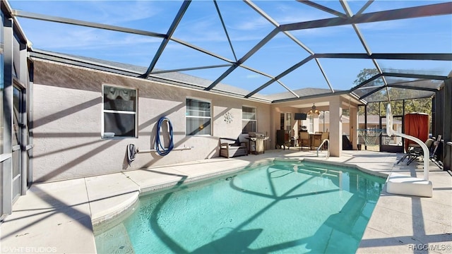 view of swimming pool with a lanai, ceiling fan, and a patio area