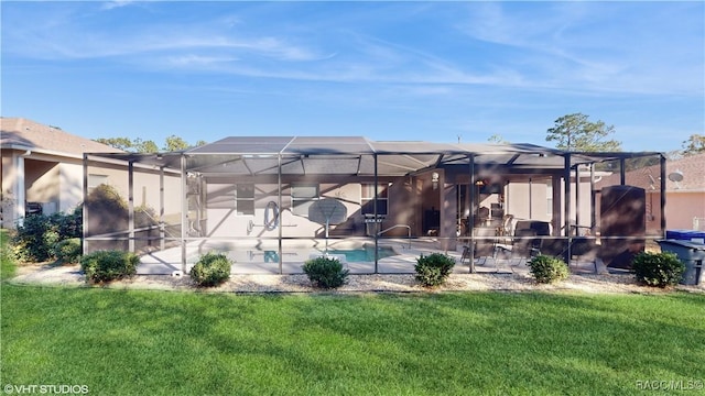 back of property with a patio area, glass enclosure, and a yard