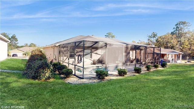 back of property with a lawn and glass enclosure