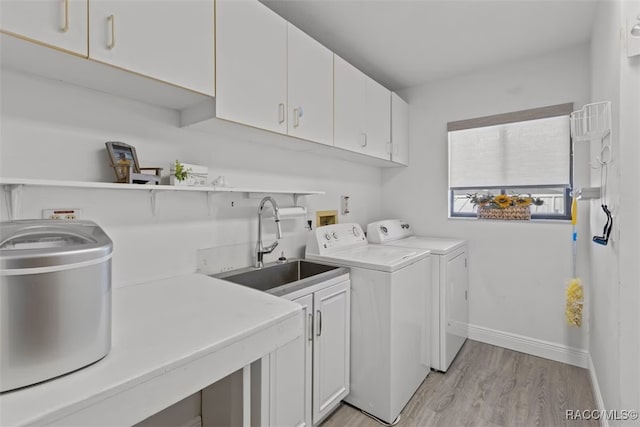 3945 N Timucua Pt, Crystal River, FL 34428 - laundry room with baseboards, light wood finished floors, a sink, separate washer and dryer, and cabinet space