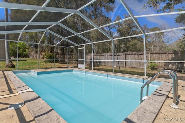 view of swimming pool with glass enclosure and a fenced backyard