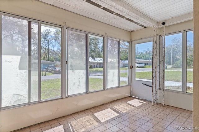 unfurnished sunroom with beam ceiling