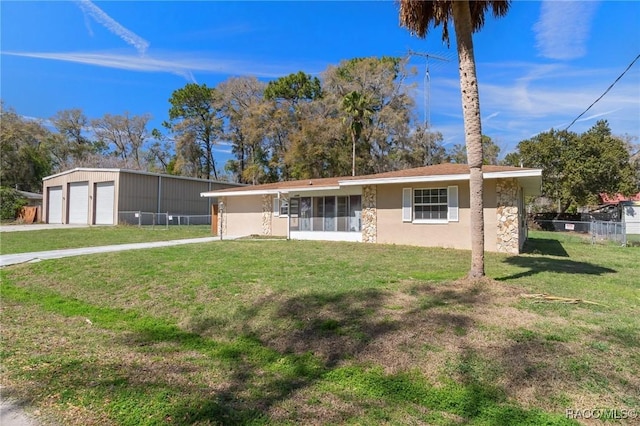 ranch-style home with a garage, a front yard, an outdoor structure, and stucco siding