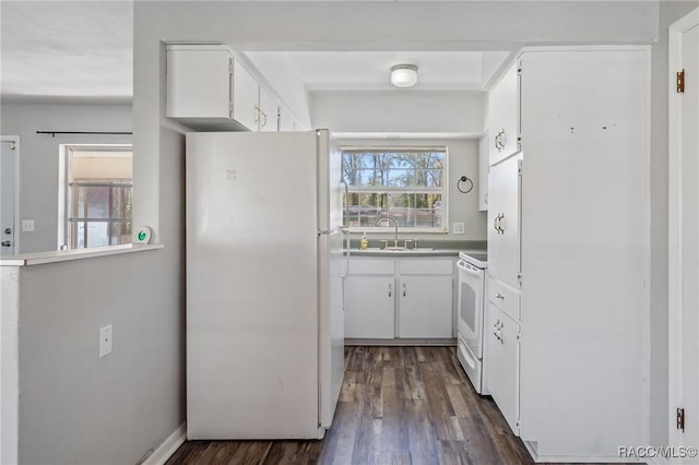 kitchen with dark wood-style floors, white appliances, white cabinets, and a sink