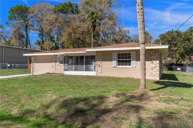 view of front of property with stone siding, fence, a front lawn, and stucco siding