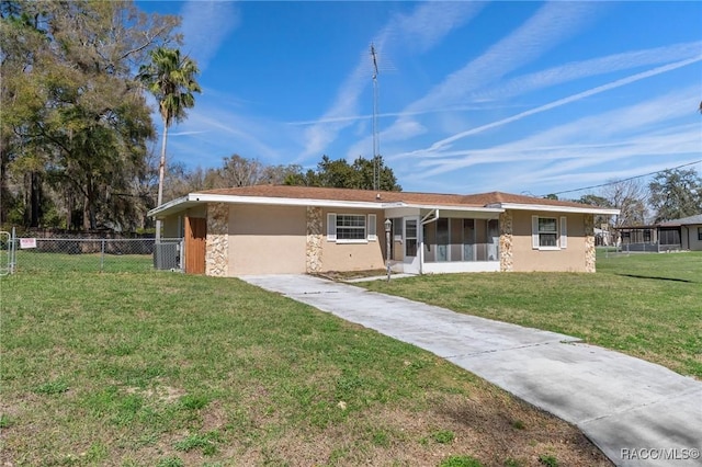 ranch-style home with driveway, stucco siding, fence, and a front yard