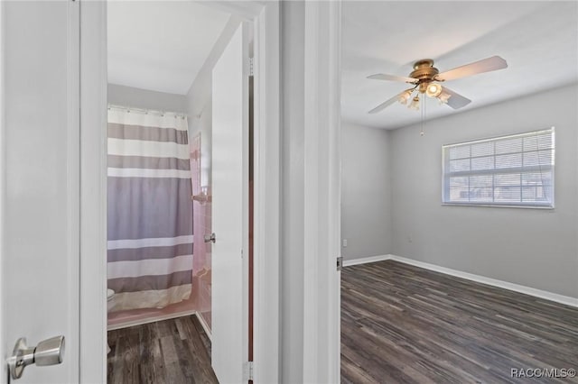 full bathroom with a shower with shower curtain, wood finished floors, a ceiling fan, and baseboards