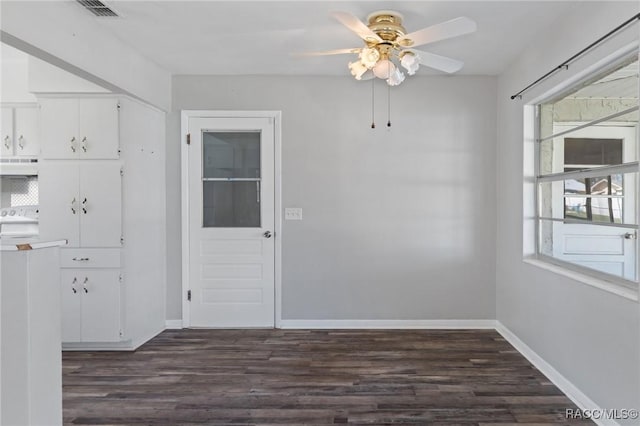 unfurnished dining area with dark wood-style floors, ceiling fan, visible vents, and baseboards