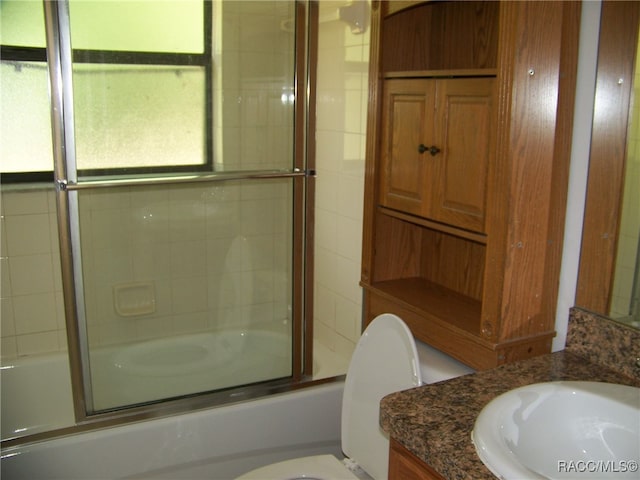 full bathroom featuring vanity, toilet, a healthy amount of sunlight, and enclosed tub / shower combo