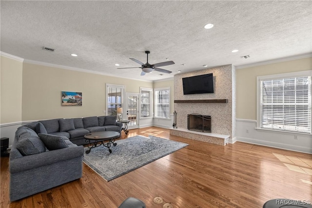 4940 E Fort King St, Ocala, FL 34470 - living area with a textured ceiling, ornamental molding, wood finished floors, ceiling fan, and a large fireplace