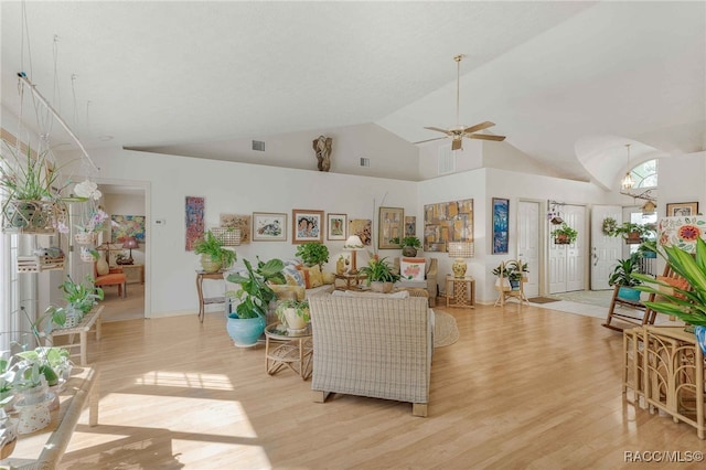 living room with a ceiling fan, visible vents, light wood finished floors, and high vaulted ceiling