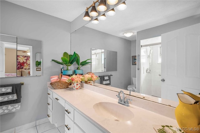 bathroom featuring toilet, a stall shower, a textured ceiling, tile patterned flooring, and vanity