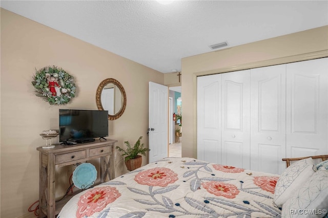 bedroom with visible vents, a closet, and a textured ceiling