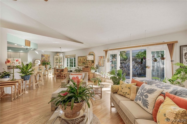 living room featuring light wood-style floors and vaulted ceiling