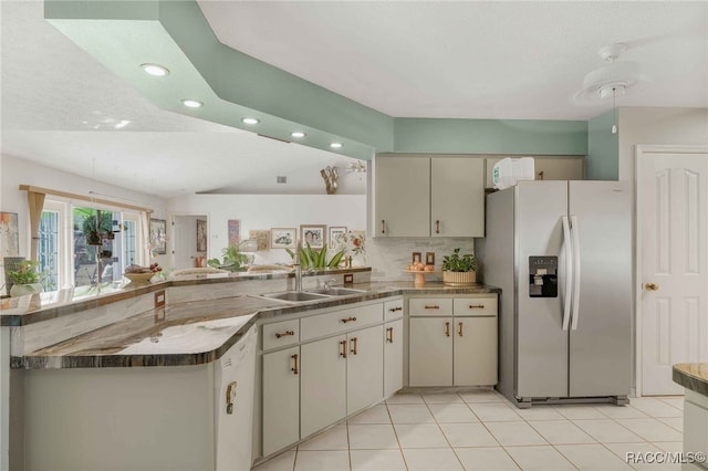 kitchen with stainless steel refrigerator with ice dispenser, a sink, backsplash, a peninsula, and dishwasher