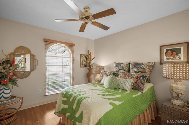 bedroom with wood finished floors, baseboards, and ceiling fan