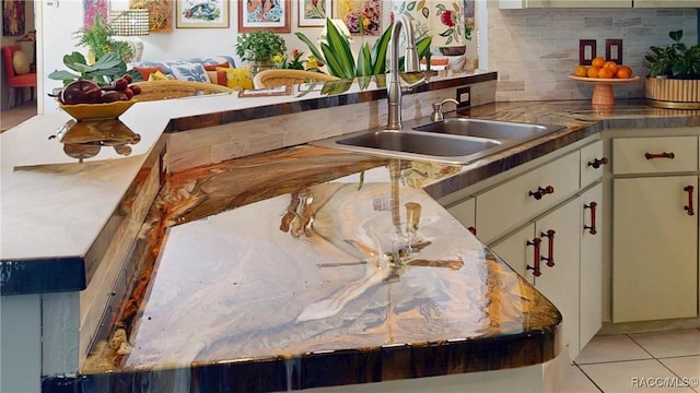 kitchen with light tile patterned floors, decorative backsplash, and a sink