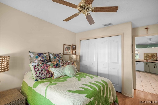 bedroom featuring light wood finished floors, visible vents, a closet, and ceiling fan